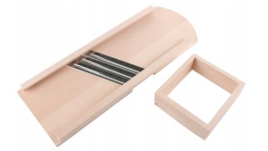 Szatkownica drewniana z trzema ostrzami do kapusty obok szuflada ułatwiająca krojenie.